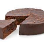 Sachertorte, Austrian chocolate cake with slice isolated on white background